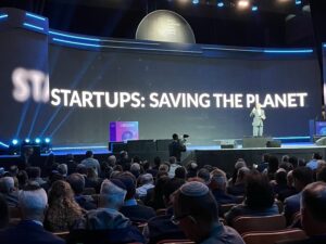 An image of a large screen projecting the theme of the OurCrowd Global Investor Summit 2023: "Startups - Saving the Planet"