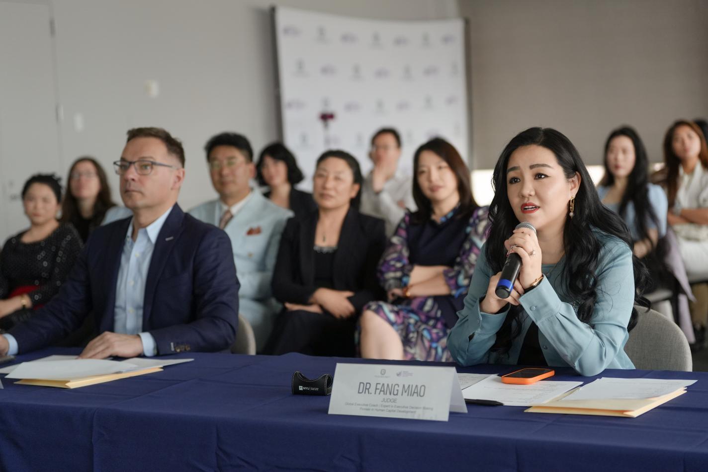 woman in panel holding a mic