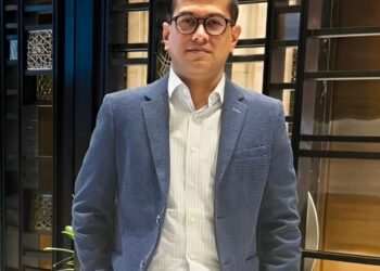 man in a blue coat wearing glasses