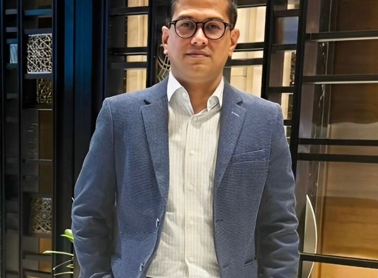 man in a blue coat wearing glasses